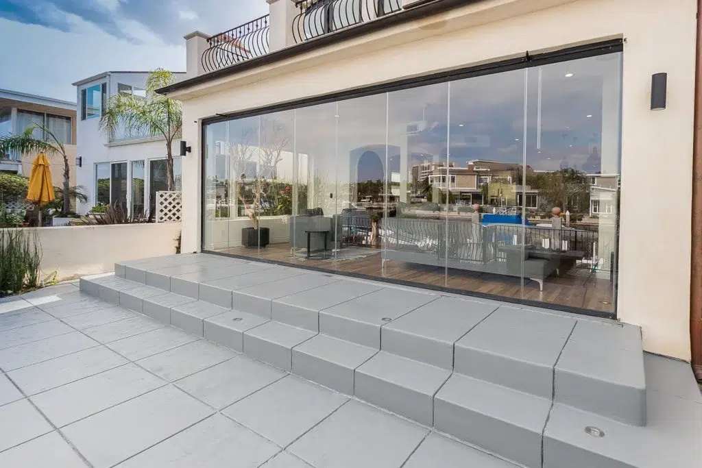 Patio with enclosed frameless sliding glass doors.
