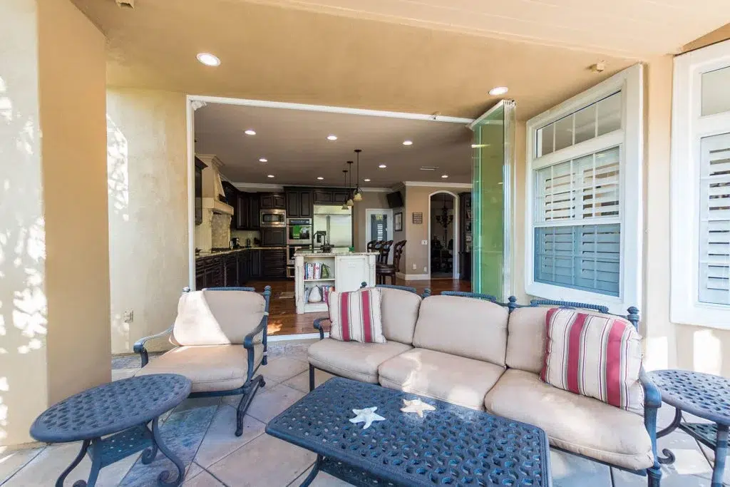 Patio with living room and stacked frameless sliding glass doors.